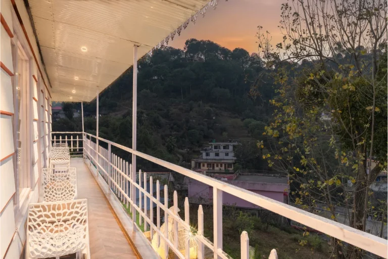 Picturesque balcony view from the Farm Suite at the best staycation villa in Kasauli surrounded by lush greenery.