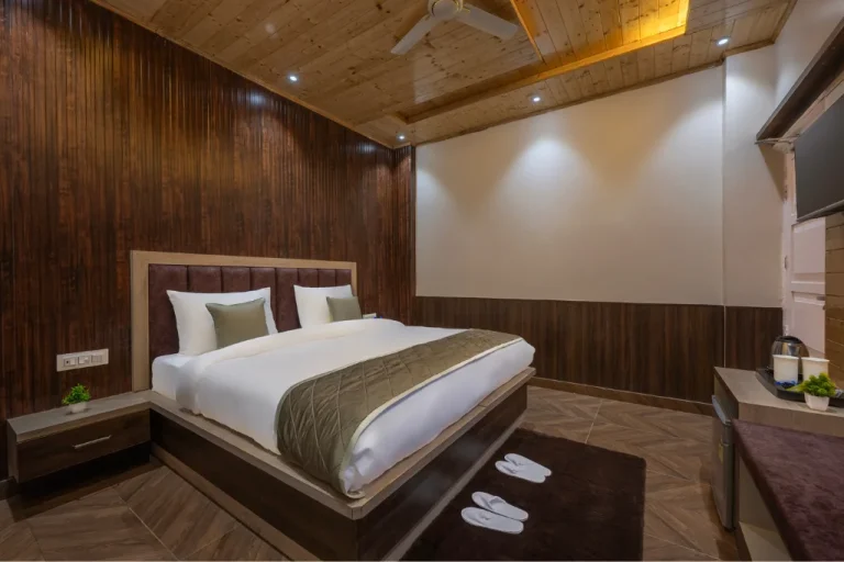 Luxurious premium suite bedroom with bedside lamps and modern wooden decor at Farmville Resort, Kasauli