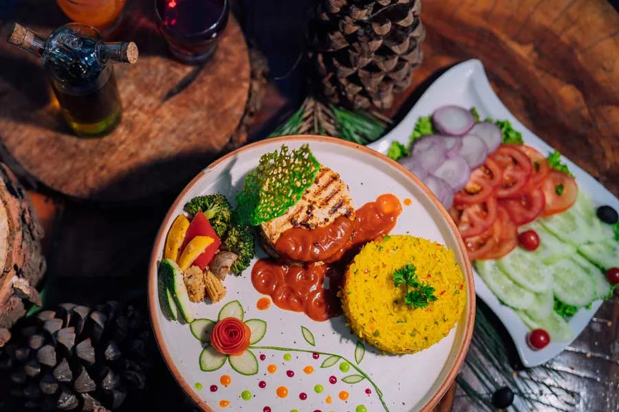 Multi-cuisine meal served with fresh vegetables in a scenic dining setting in Kasauli