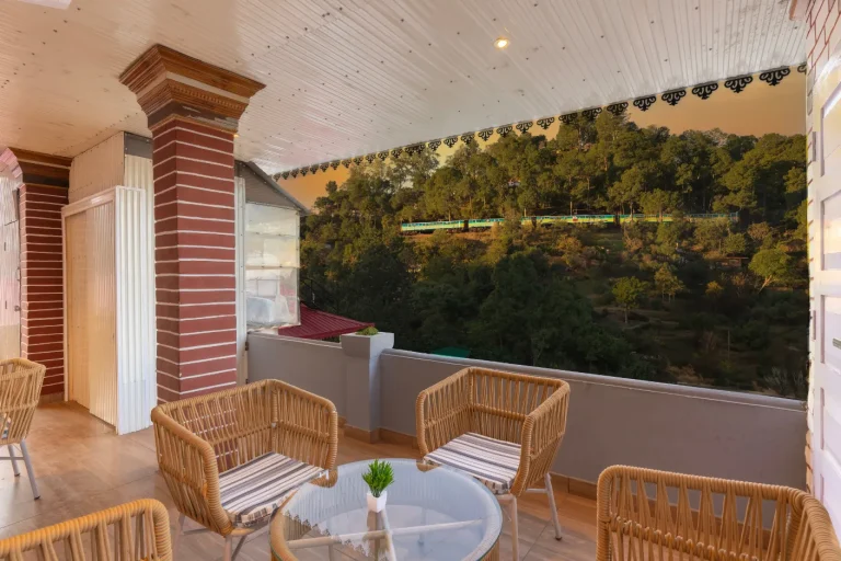 Scenic summer retreat at a luxury villa in Kasauli – outdoor seating with a stunning valley view, cool breeze, and a peaceful ambiance.
